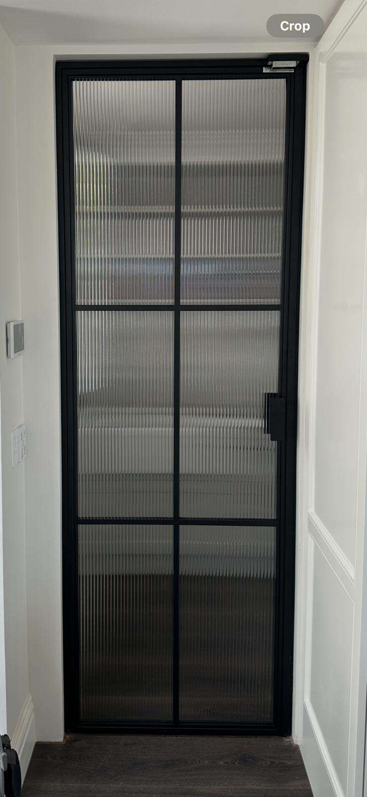 Steel-framed glass door with reeded glass