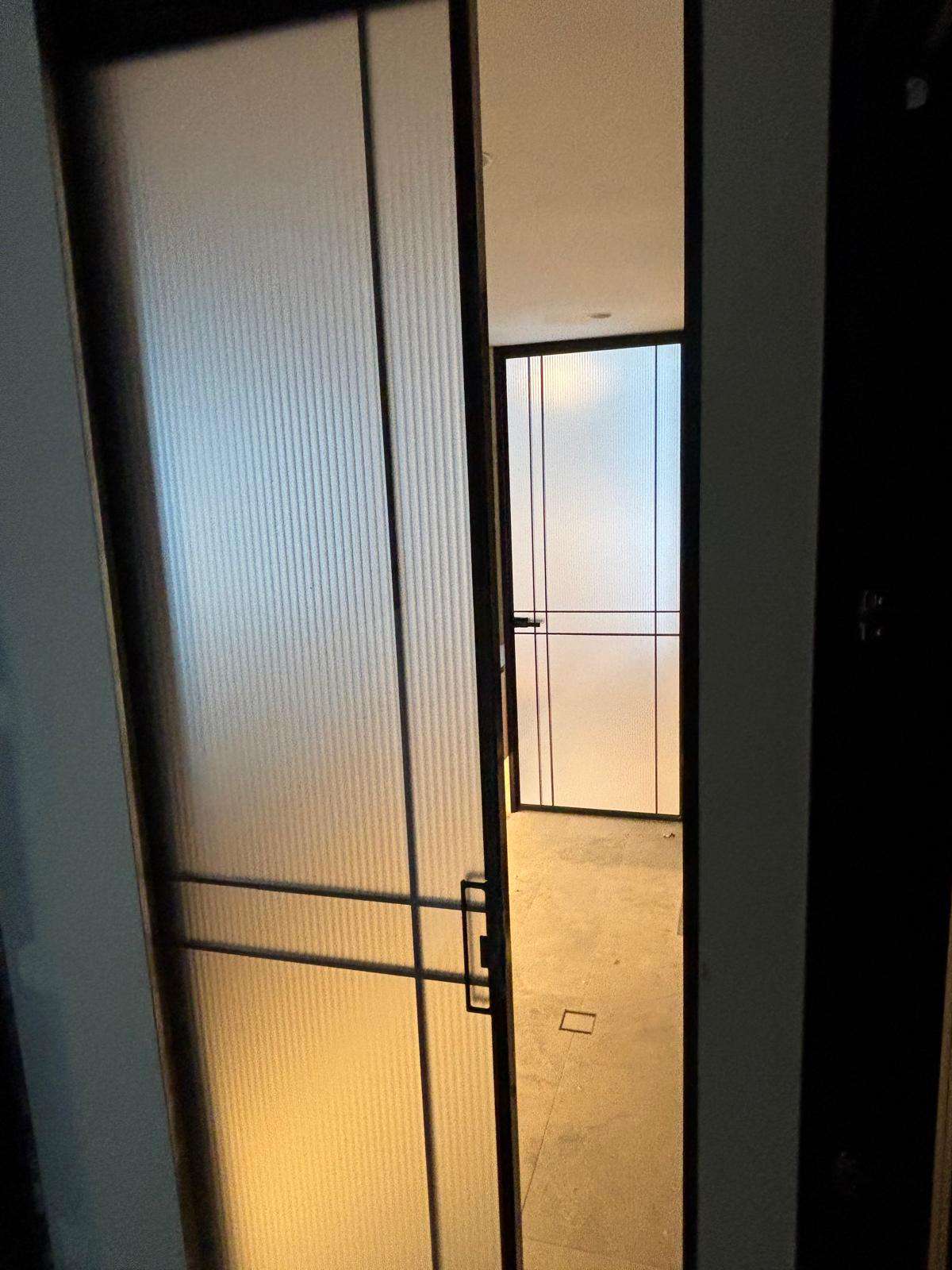 Steel-framed glass door with fluted panels