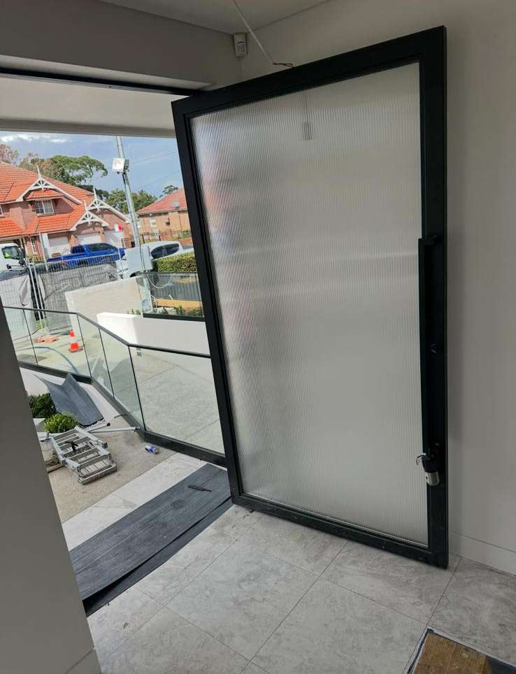 Glass pivot door and glass balustrade