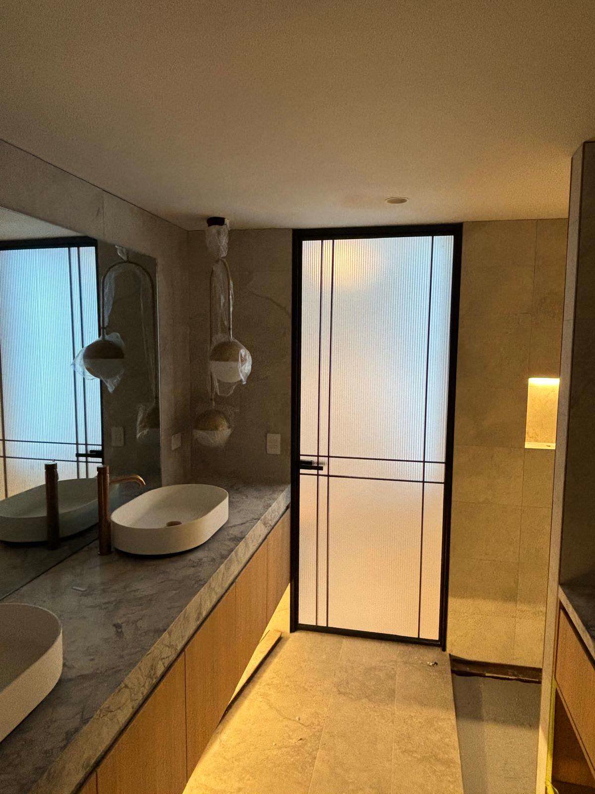 Black steel-framed glass door installed in a bathroom
