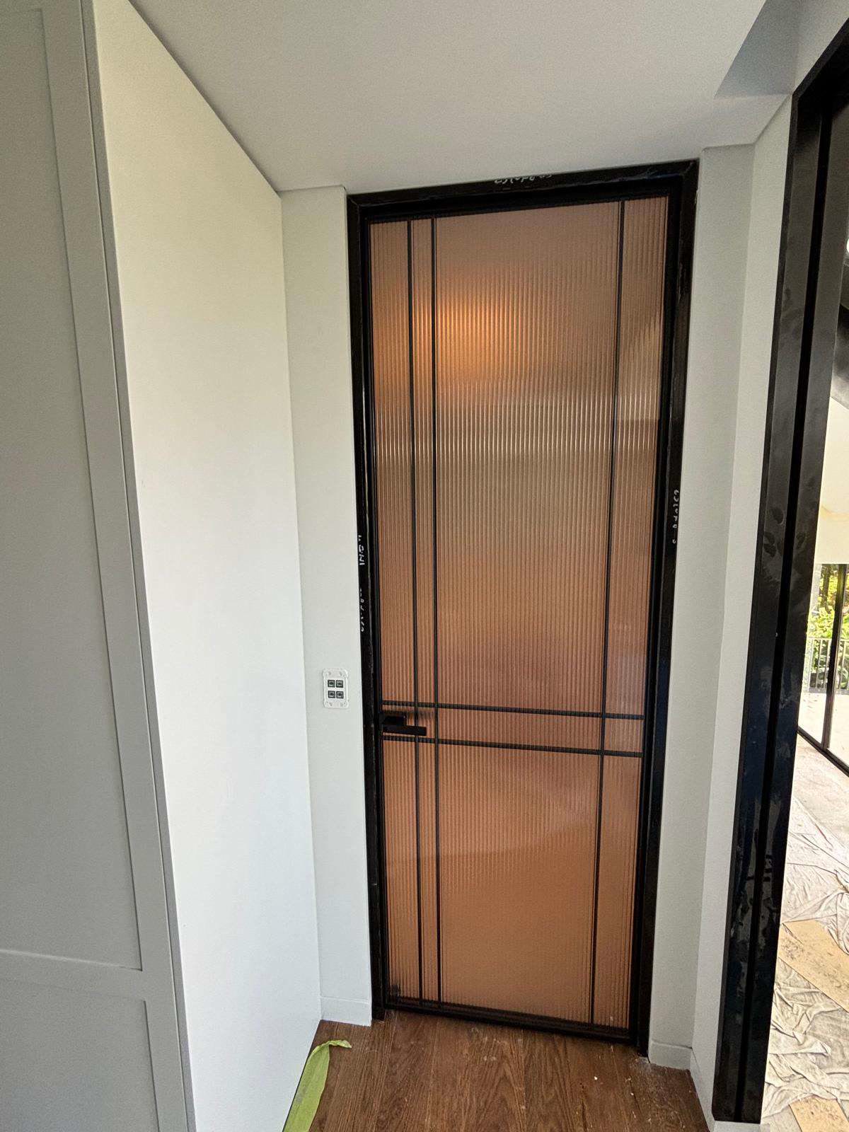 Steel-framed glass door with fluted glass